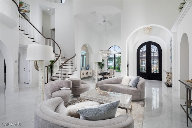 entrance foyer with a towering ceiling, an inviting chandelier, and french doors