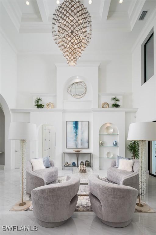 living room featuring coffered ceiling, a towering ceiling, crown molding, and built in shelves