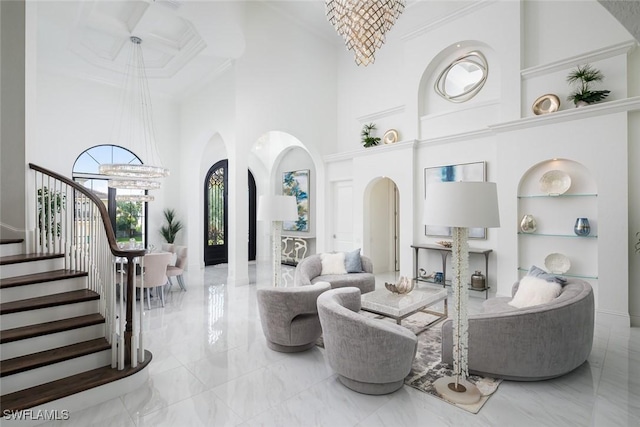 living room with a notable chandelier, built in shelves, and a high ceiling