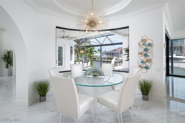 dining area with a tray ceiling, crown molding, a chandelier, and a water view