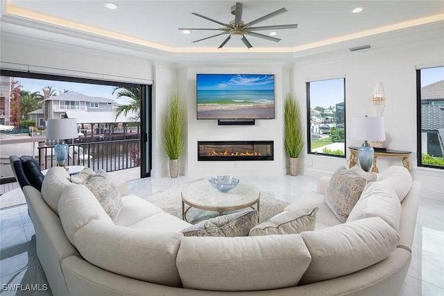 living room with crown molding, a healthy amount of sunlight, and a tray ceiling