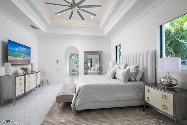 bedroom with multiple windows, crown molding, ceiling fan, and a tray ceiling