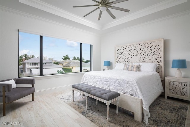 bedroom featuring hardwood / wood-style floors, crown molding, a raised ceiling, and ceiling fan