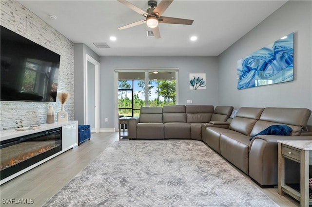 living room featuring a ceiling fan, recessed lighting, visible vents, and light wood finished floors