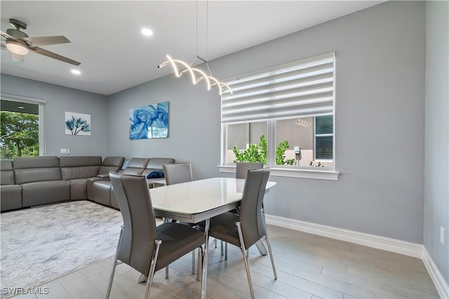 dining space with ceiling fan with notable chandelier, baseboards, a wealth of natural light, and recessed lighting