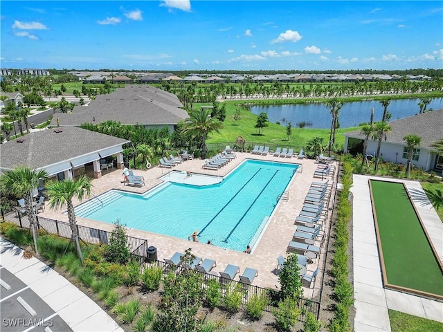 community pool with a water view, a patio, and fence