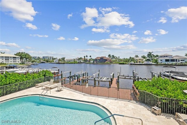 view of pool with a patio area, a dock, and a water view