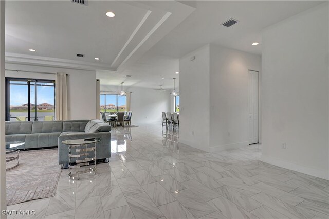 tiled living room featuring a raised ceiling