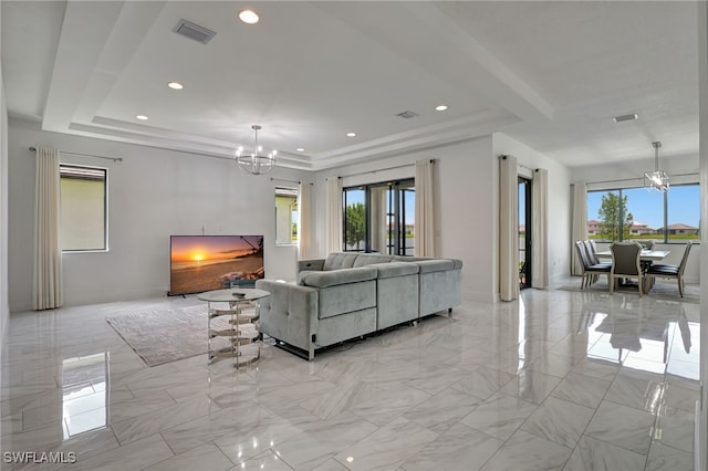 living room with a chandelier and a tray ceiling