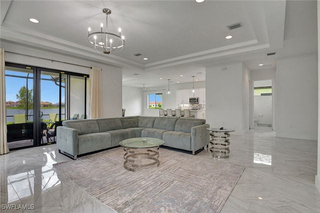 living room featuring a notable chandelier and a raised ceiling