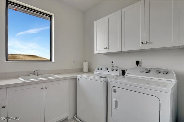 laundry room featuring cabinets, sink, and washing machine and clothes dryer