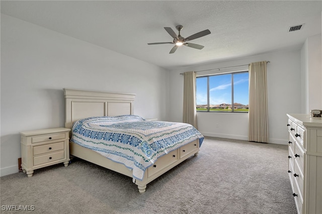 carpeted bedroom with a textured ceiling and ceiling fan