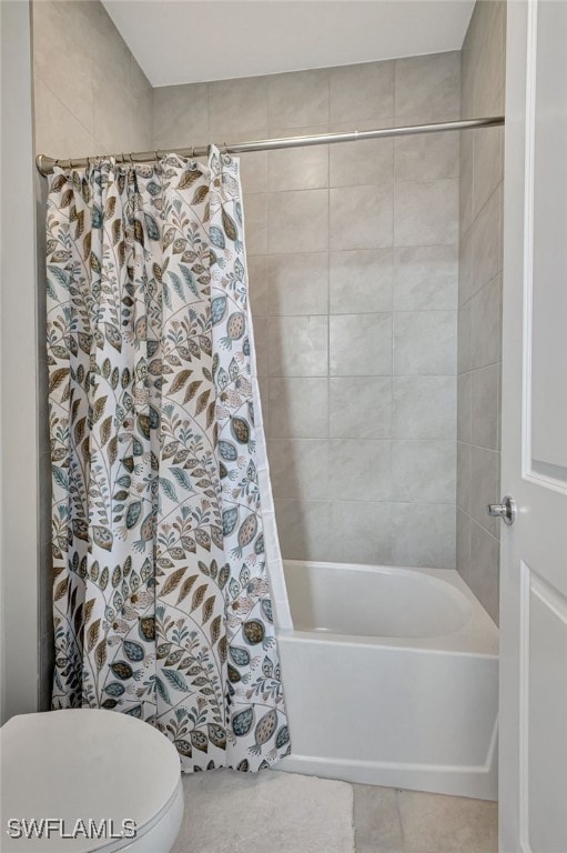 bathroom featuring tile patterned flooring, toilet, and shower / bath combo