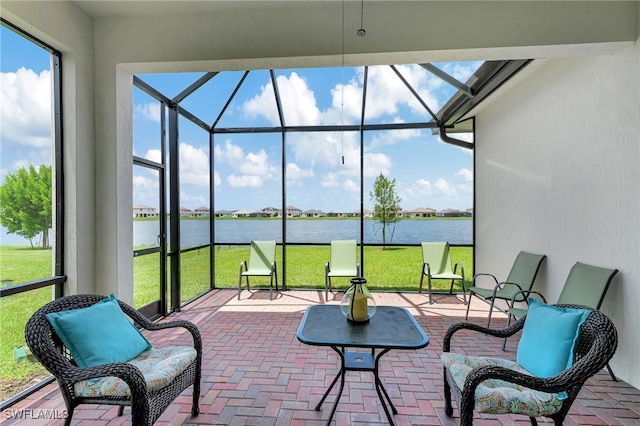 view of patio with a water view and glass enclosure