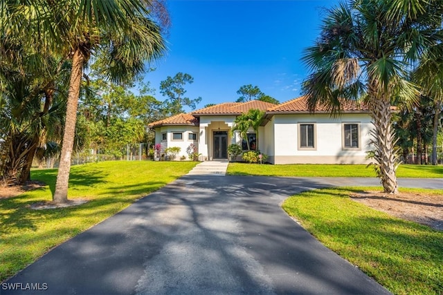 mediterranean / spanish home featuring a front lawn