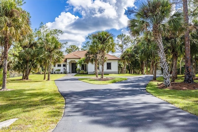 mediterranean / spanish-style house with a front yard