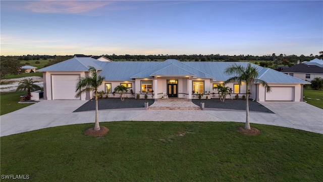 view of front of property featuring a garage and a yard