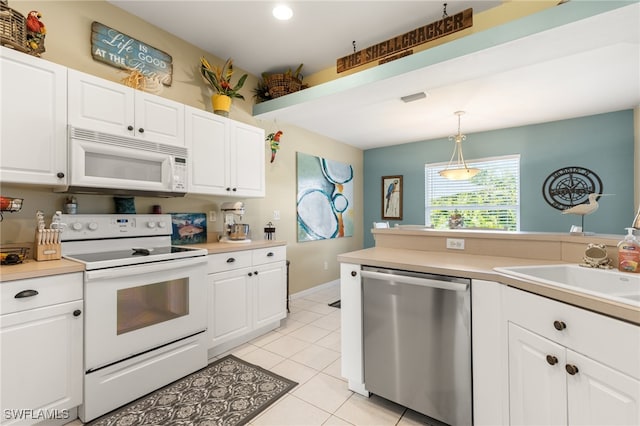 kitchen with white cabinets, pendant lighting, sink, light tile patterned floors, and white appliances