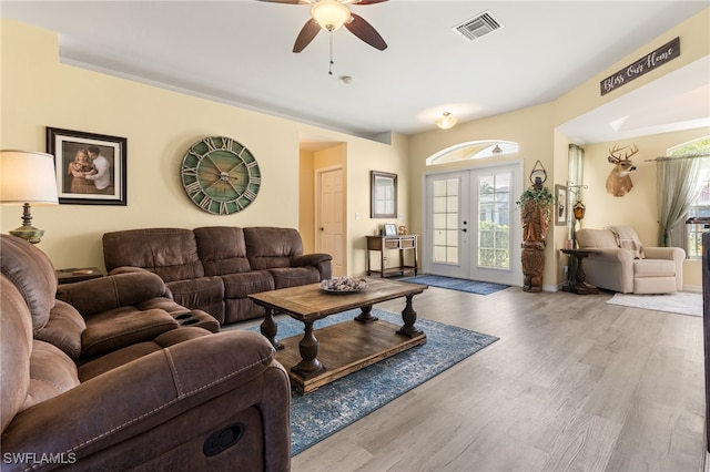 living room with wood-type flooring, ceiling fan, plenty of natural light, and french doors