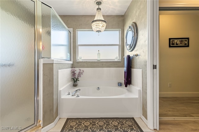 bathroom with independent shower and bath, a chandelier, and wood-type flooring