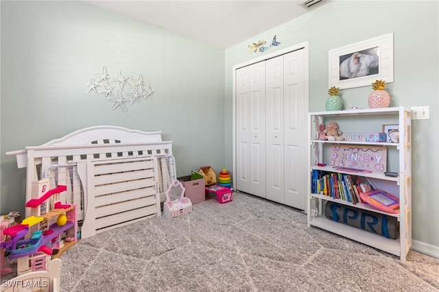 bedroom with a closet, a nursery area, and carpet floors