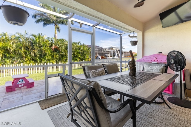 sunroom / solarium featuring ceiling fan