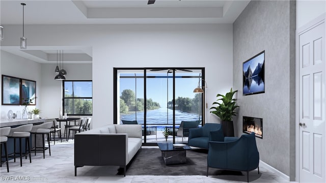 tiled living room featuring ceiling fan, a towering ceiling, and a tray ceiling