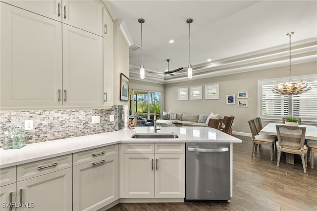 kitchen with dishwasher, decorative light fixtures, a raised ceiling, and sink