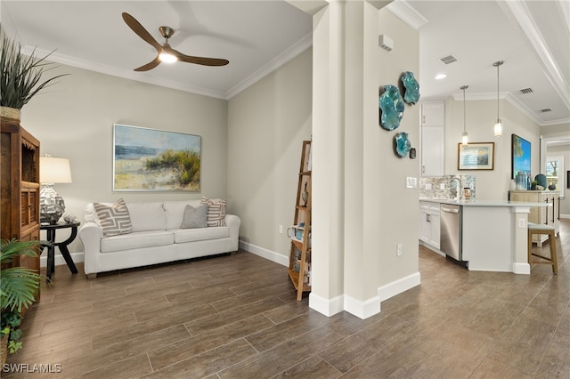 living room featuring dark wood-type flooring, ceiling fan, ornamental molding, and sink