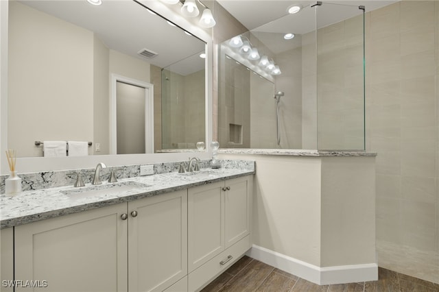 bathroom featuring vanity and tiled shower