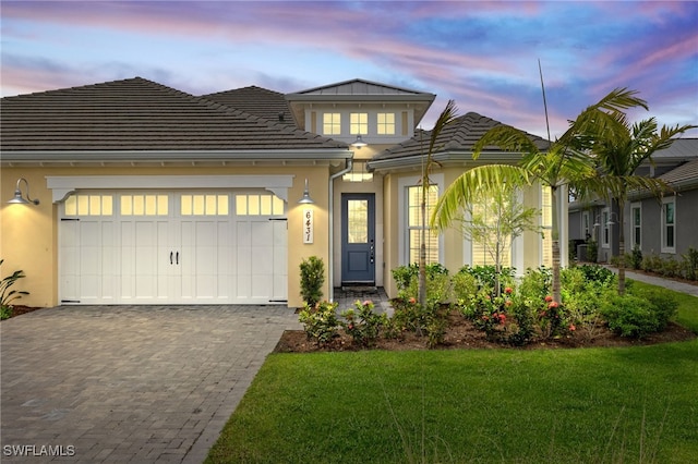 view of front of property featuring a yard and a garage