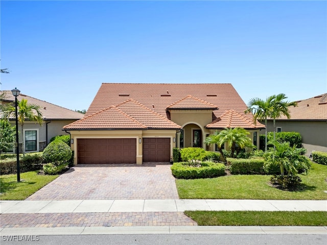 mediterranean / spanish-style house featuring a front lawn and a garage