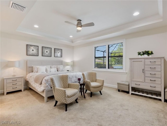 carpeted bedroom with ceiling fan, ornamental molding, and a raised ceiling