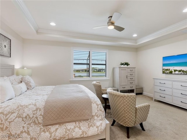 bedroom featuring ceiling fan, light colored carpet, ornamental molding, and a raised ceiling