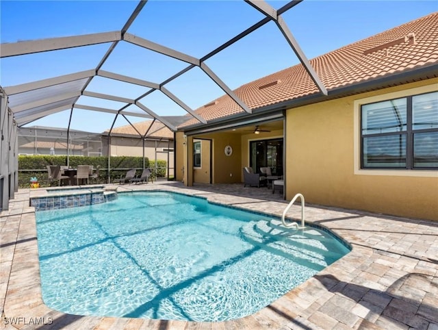 view of pool with an in ground hot tub, ceiling fan, a lanai, and a patio