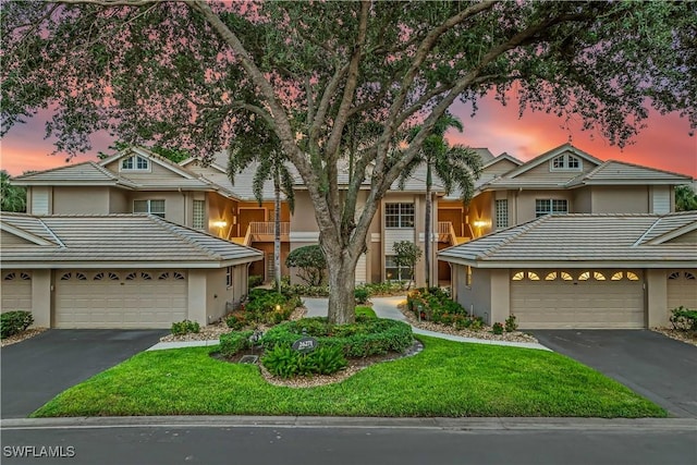 view of property featuring stucco siding, driveway, and a tile roof