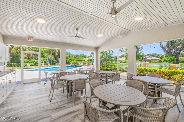 view of patio / terrace with outdoor dining area, a ceiling fan, and an outdoor pool