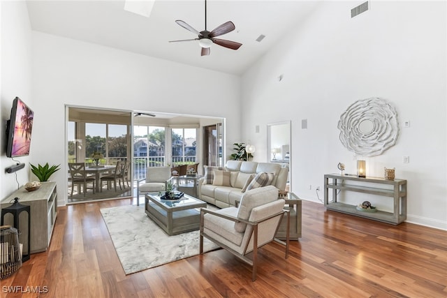 living room featuring high vaulted ceiling, wood finished floors, visible vents, and ceiling fan