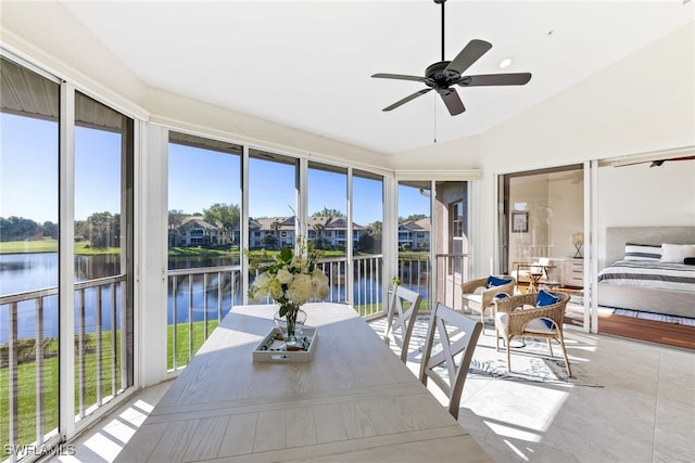 sunroom featuring a water view, ceiling fan, and vaulted ceiling