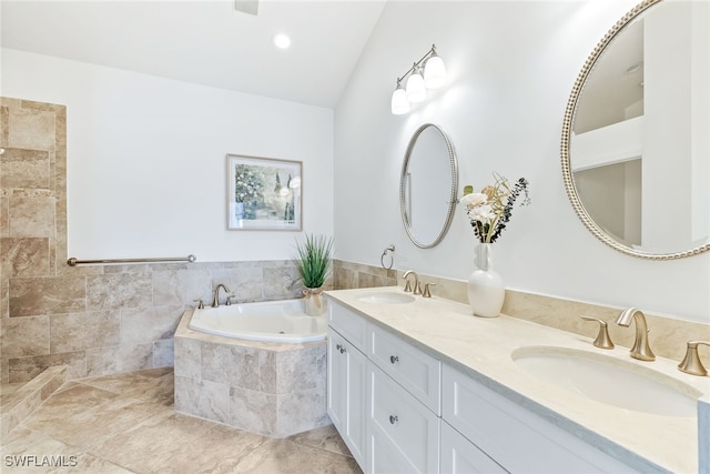 bathroom featuring a garden tub, vaulted ceiling, double vanity, and a sink