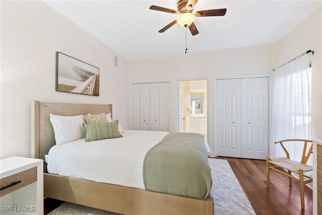 bedroom featuring a ceiling fan, visible vents, dark wood-style flooring, and two closets