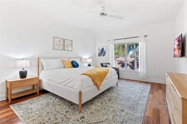 bedroom with baseboards, wood finished floors, and a ceiling fan