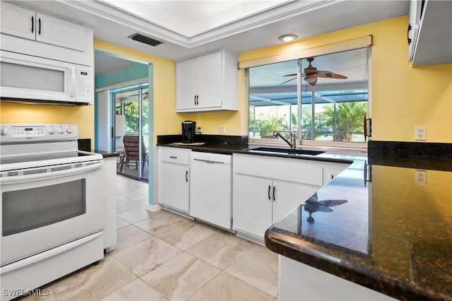 kitchen with white appliances, a tray ceiling, white cabinetry, and crown molding