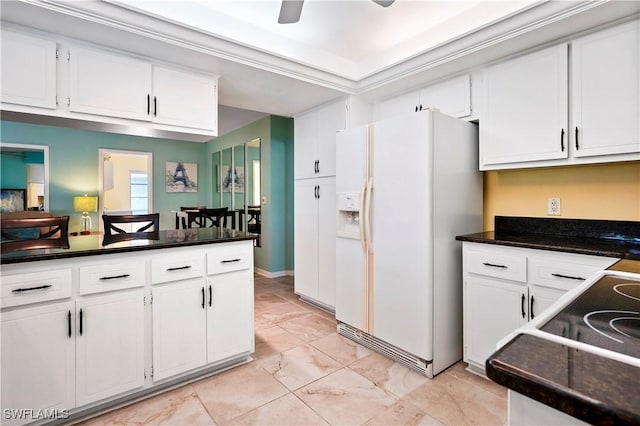 kitchen featuring ceiling fan, white cabinetry, white refrigerator with ice dispenser, and crown molding