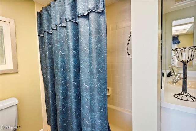 bathroom featuring shower / tub combo with curtain and toilet