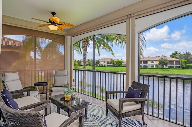 sunroom / solarium featuring a water view, plenty of natural light, and ceiling fan