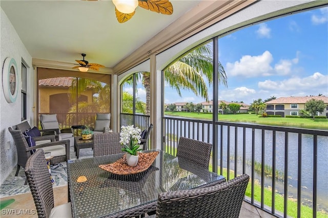 sunroom / solarium with a water view, ceiling fan, and a wealth of natural light