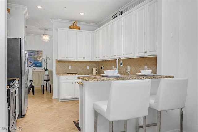 kitchen with stainless steel range with electric cooktop, white cabinets, a kitchen breakfast bar, hanging light fixtures, and kitchen peninsula