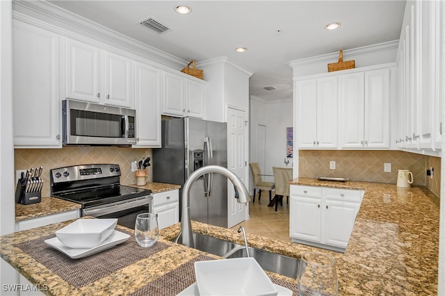 kitchen featuring sink, decorative backsplash, white cabinets, and appliances with stainless steel finishes