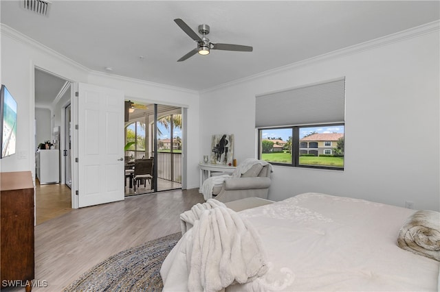 bedroom featuring multiple windows, crown molding, and access to outside